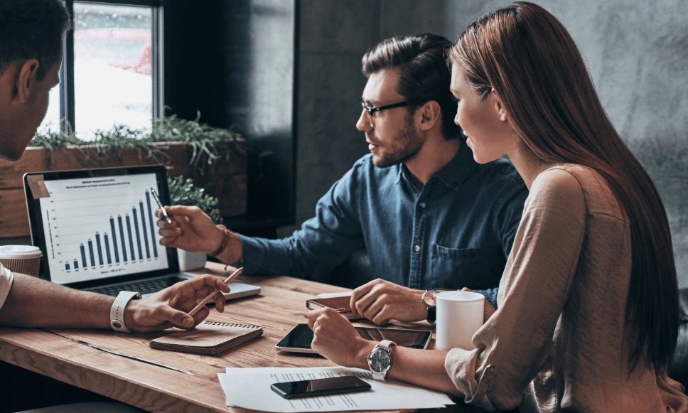 Person presenting bar chart to other staff members